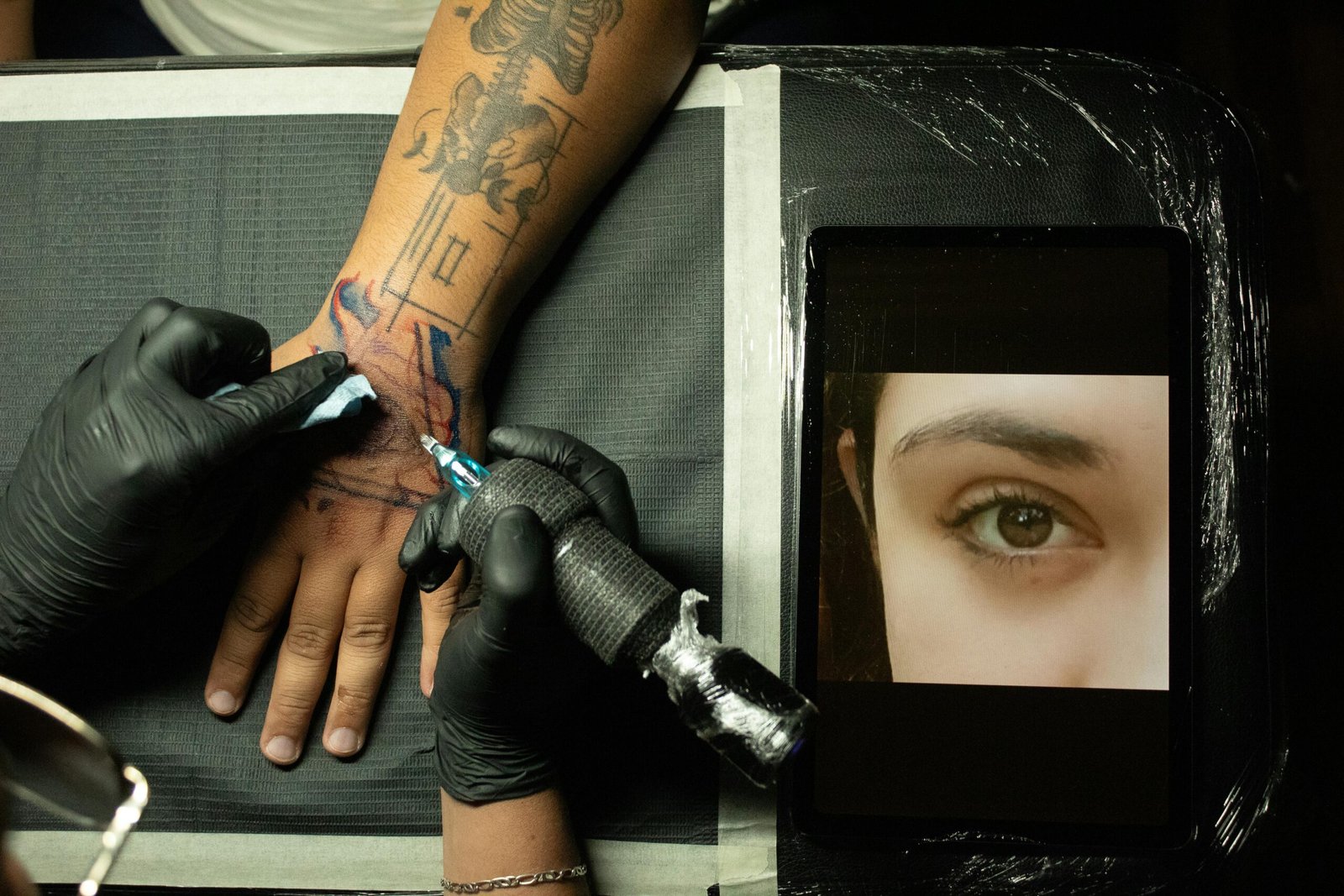 Close-up of a tattoo artist creating a design on a person's arm, Ciudad de México.